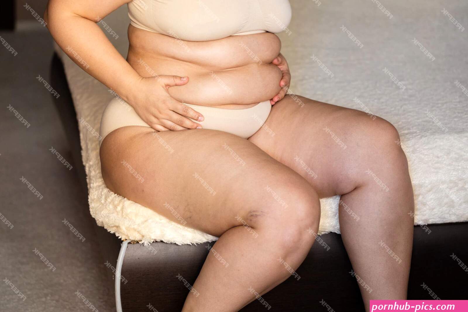 Premium Photo | Unrecognizable fat woman sitting on edge of beige plaid in nude bra underpants showing squeezing excess naked belly
