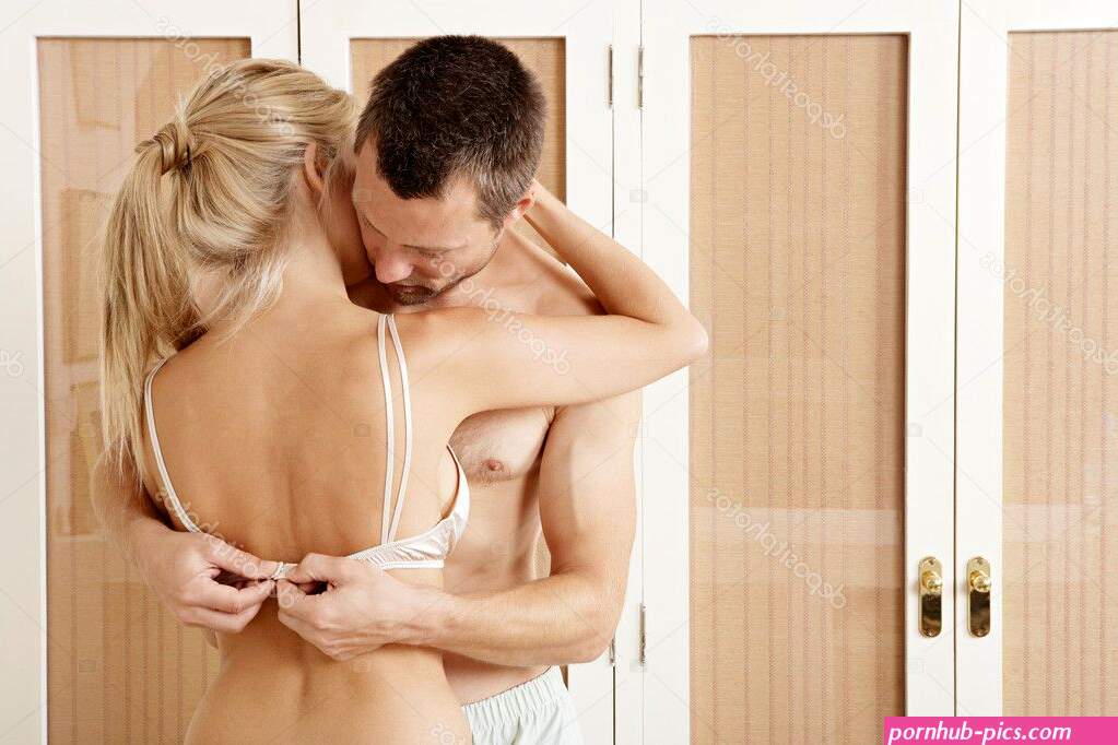 Sexy couple hugging and kissing in bedroom. Man undressing woman. Stock Photo by ©mjth 19803711