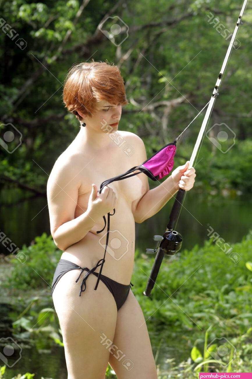A Lovely, Sexy, Young Topless Girl With Her Bikini Bra Hanging From A Fishing Rod, Stands On A Creekbank In A Lush, Tropical Forest. Stock Photo, Picture And Royalty Free Image. Image