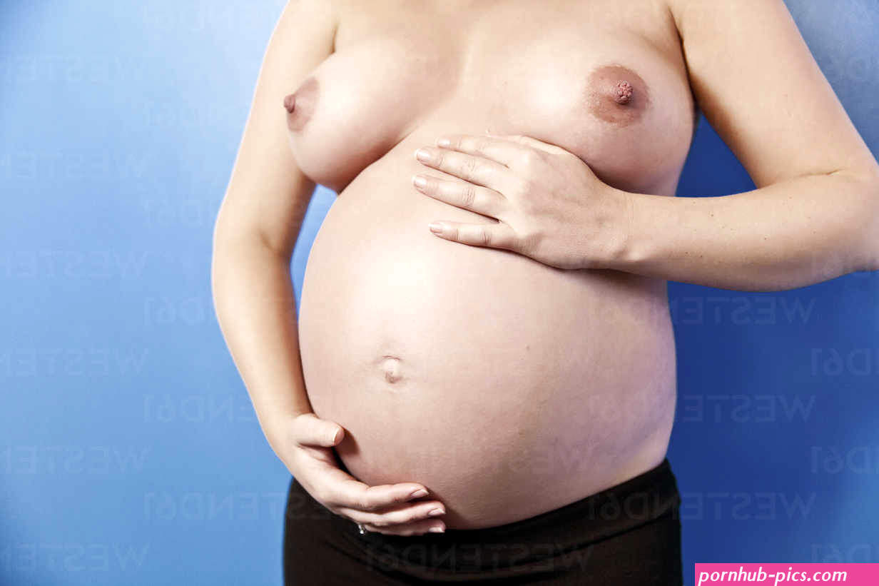 Pregnant woman showing belly and breast stock photo