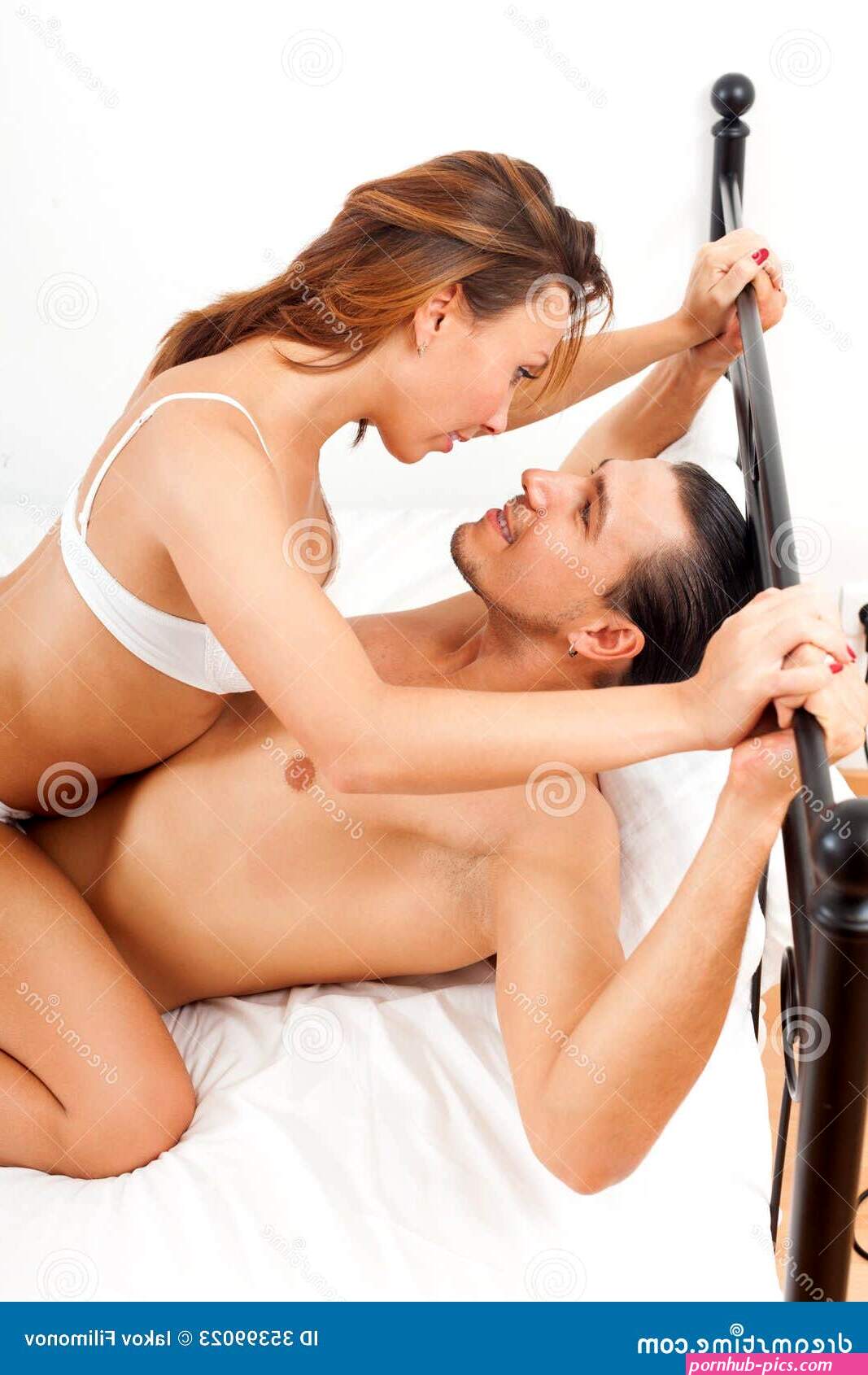 Playfull Adult Couple Having Sex on Bed in Bedroom Interior Stock Image