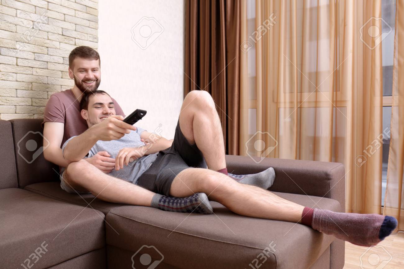 Happy Gay Couple Watching TV On Sofa At Home Stock Photo Picture and Royalty Free Image. Image 110839845.