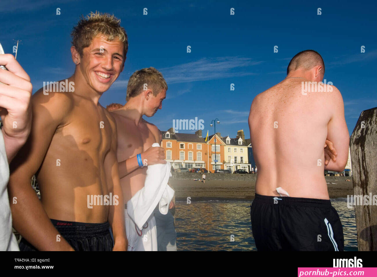 Sonriente joven adolescente chested desnudos chicos Aberystwyth North Beach Ceredigion Gales Cymru UK Fotografa de stock