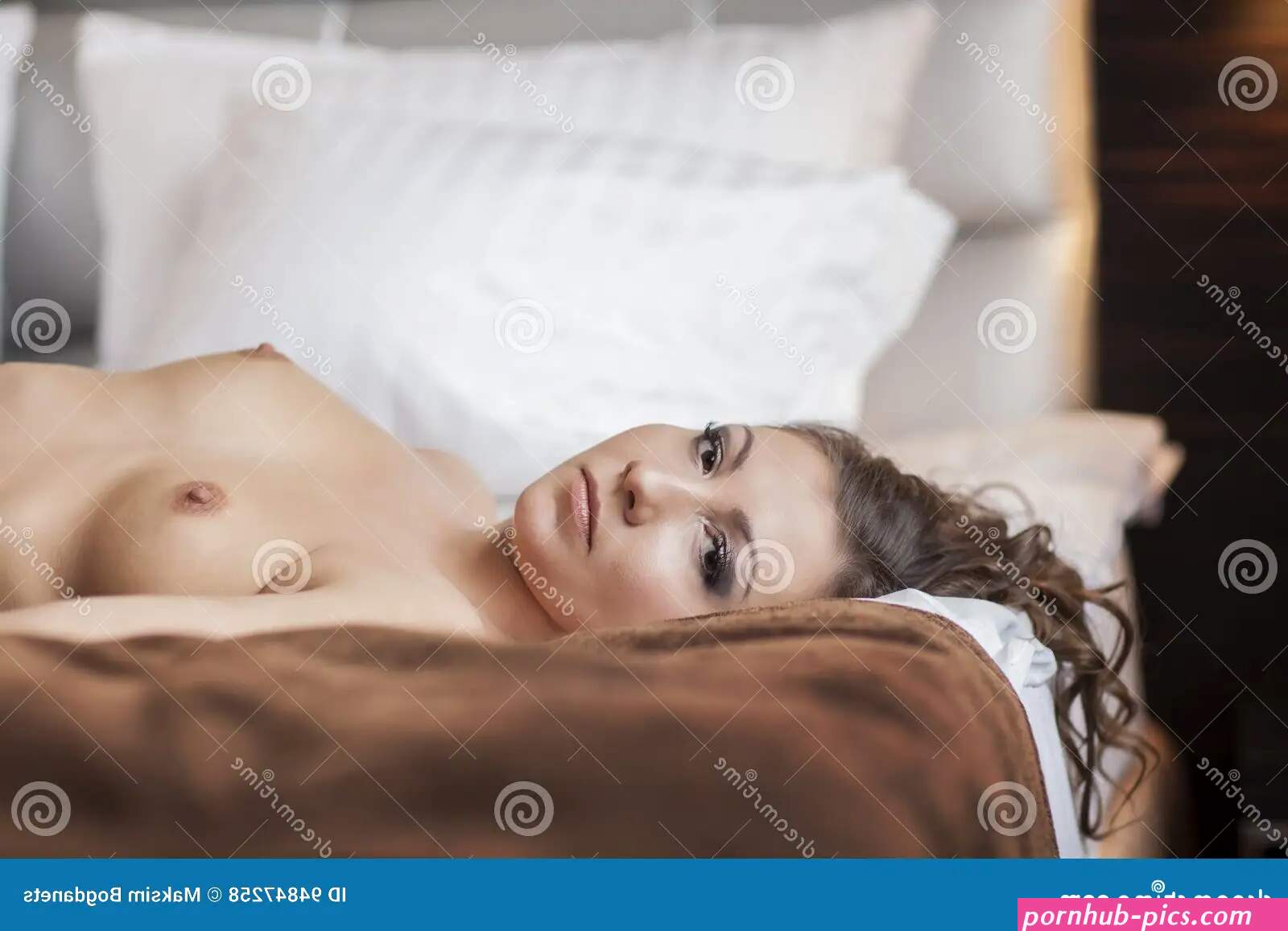 Beautiful Brunette Woman Lying in Bed on Blanket with Naked Breasts Stock Photo
