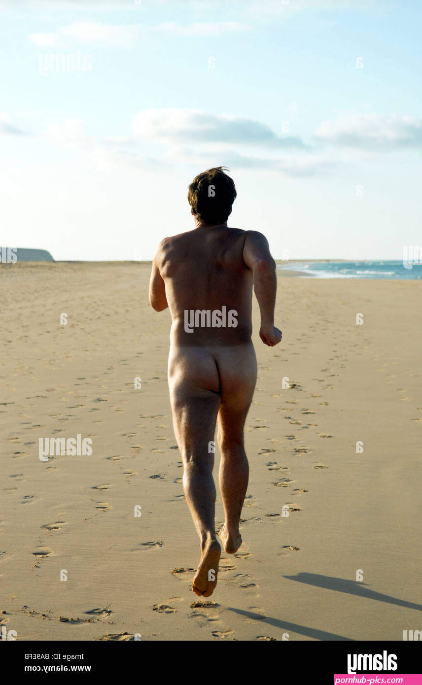 A naked man running alone on a large sandy beach in Sotovento Fuerteventura Stock Photo