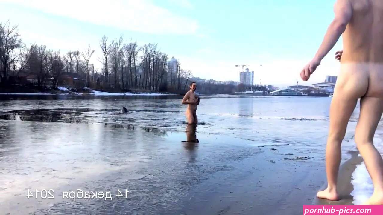 Naked russian men swim in a frozen lake