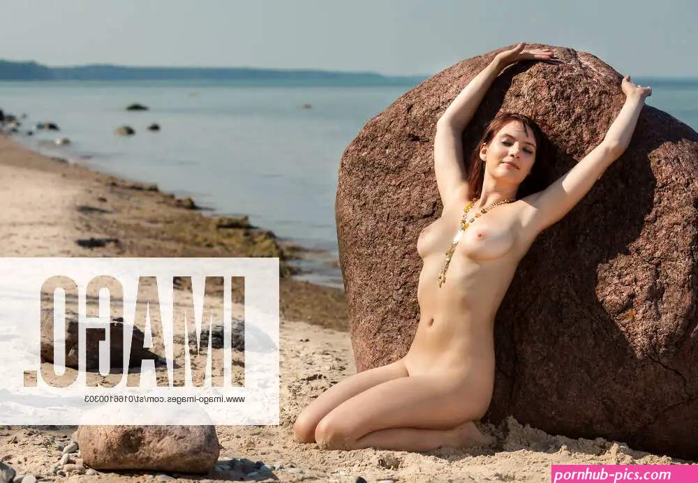 Young naked woman sunbathing near the stone on sea background model released 15119508 active
