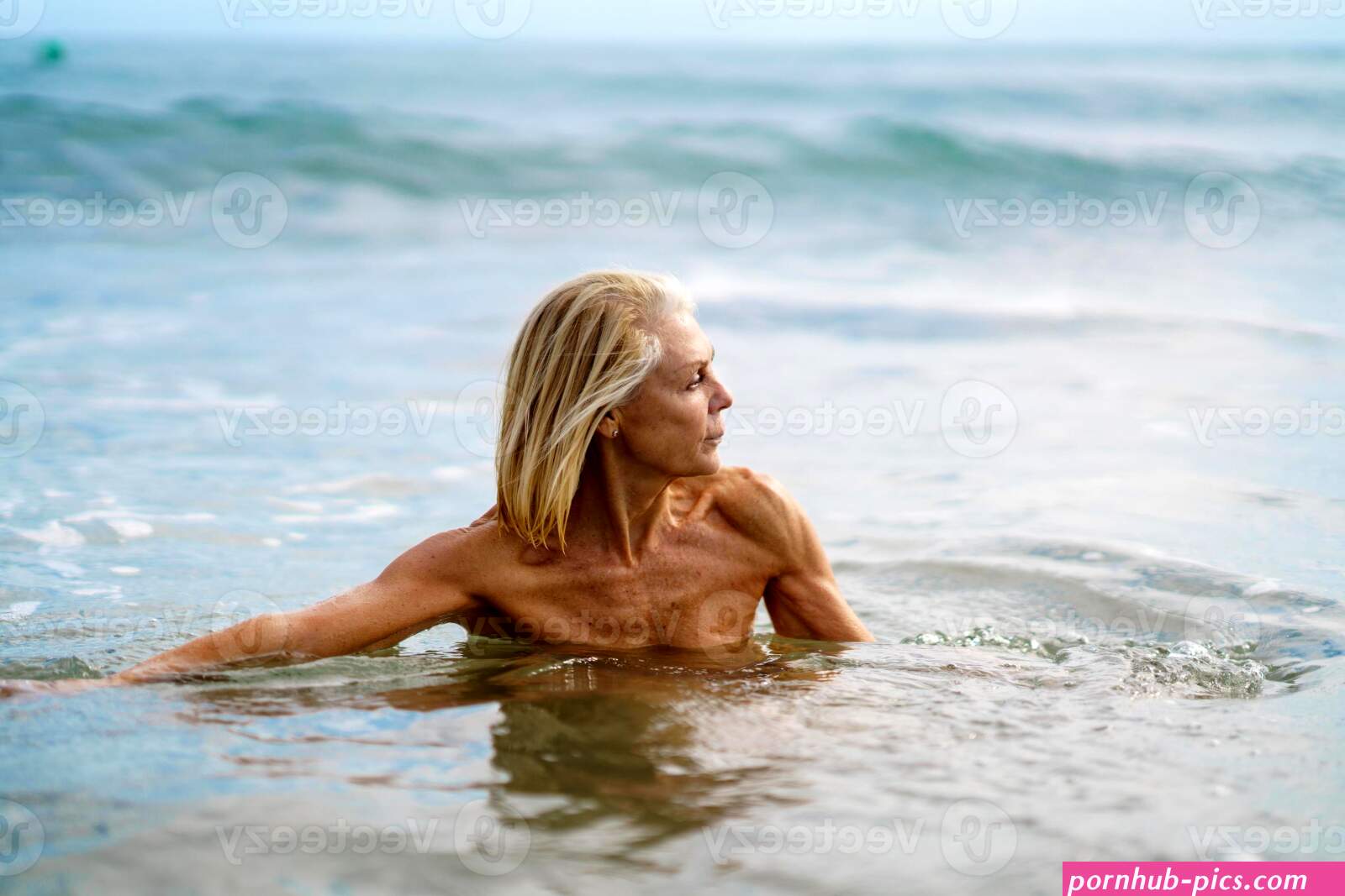 Mature woman in good shape bathing in the sea. 6172380 Stock Photo at Vecteezy