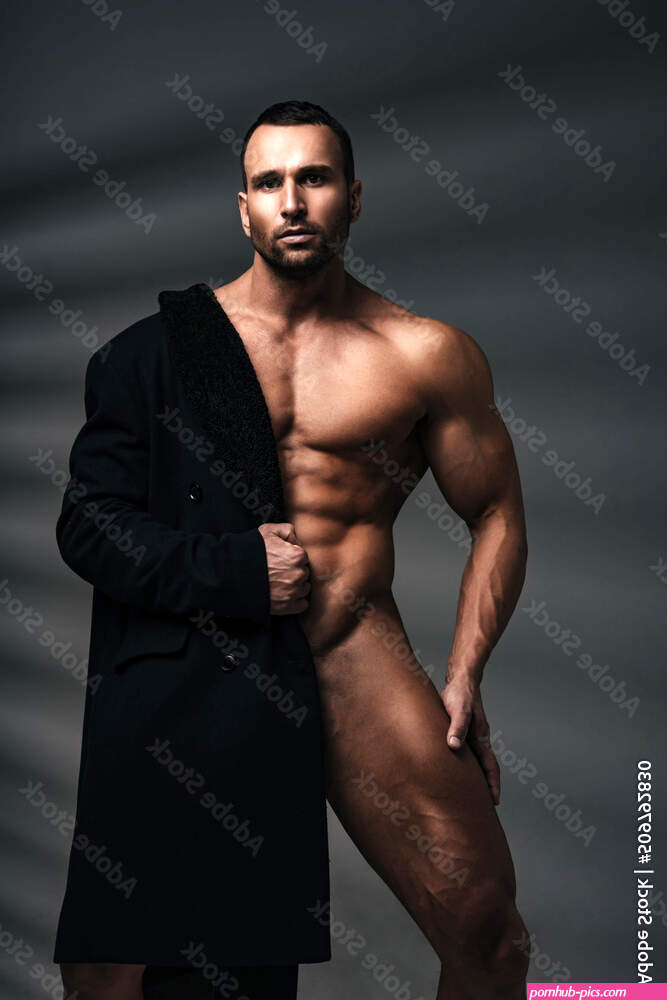 Naked handsome man with coat covered half of his body. Fashion naked male model. Stock Photo