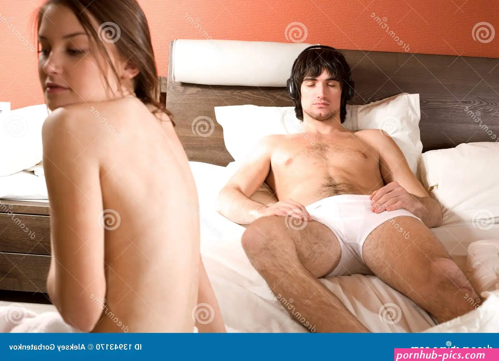 Boy in Headphones in Bed and Naked Girl Stock Photo