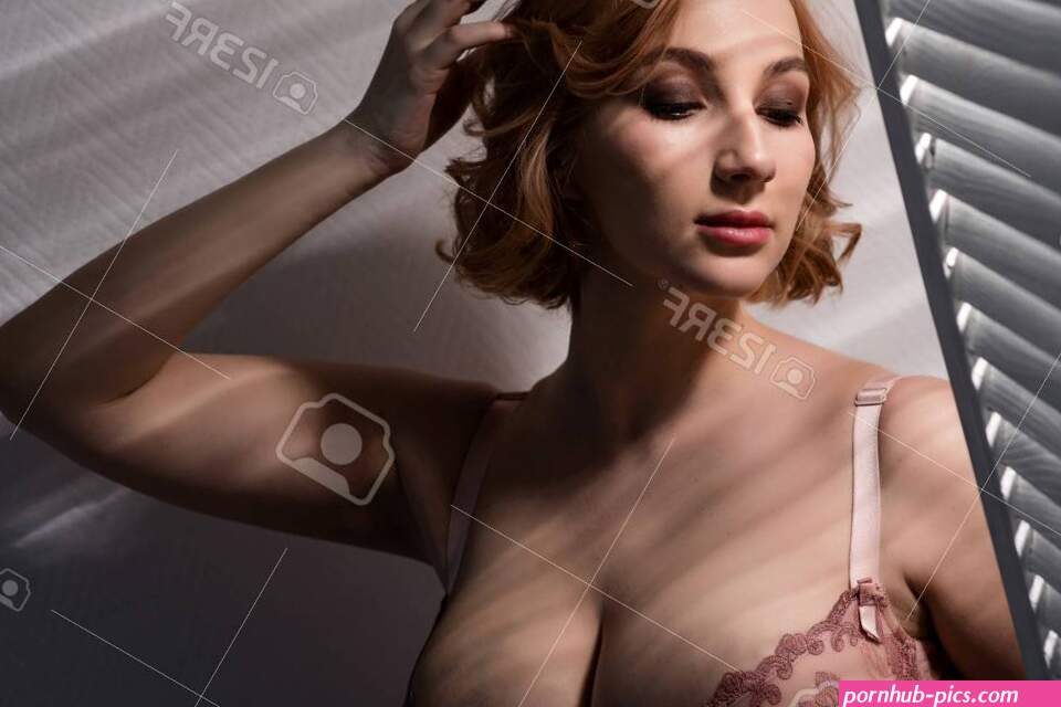 A Beautiful Young Woman With Very Large Natural Breasts Is Standing By The Window With Shutters. A Girl In Pink Lace Shows A Beautiful Figure Next To A White Screen. Huge Female
