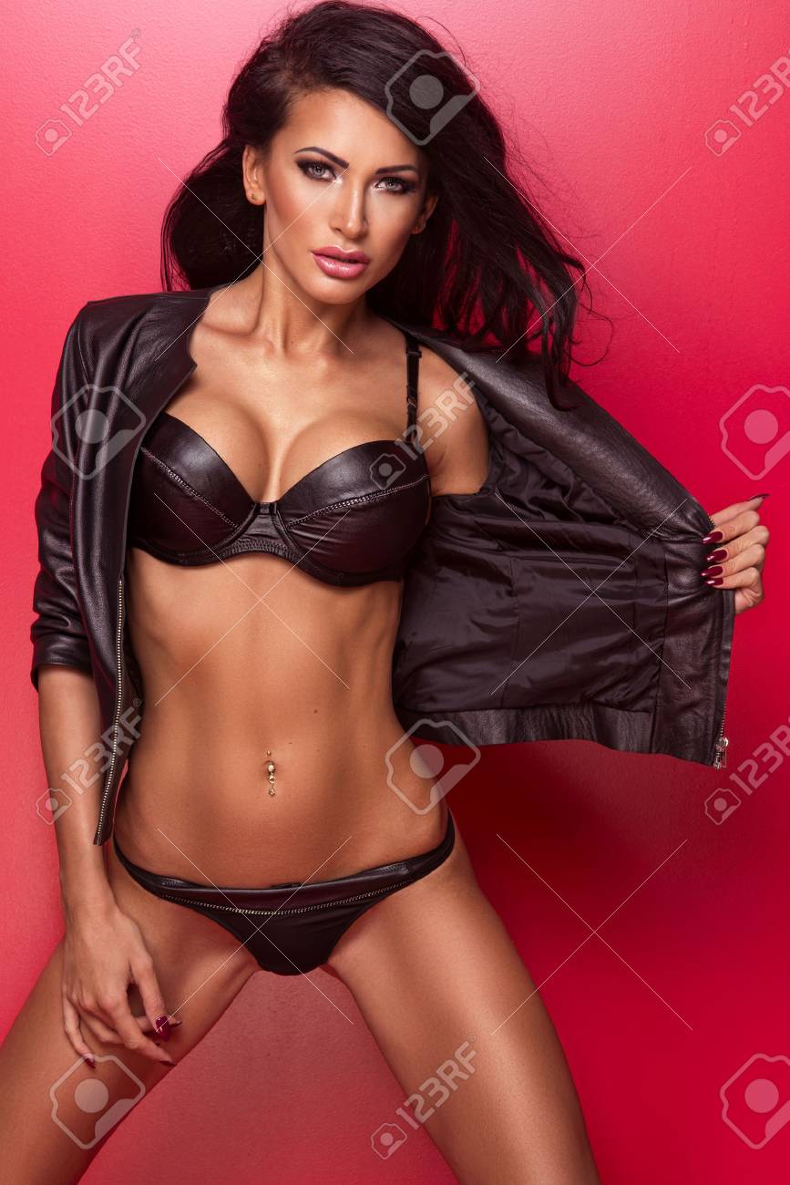 Sexy Beautiful Brunette Woman In Black Leather Lingerie Posing Over Red Background. -. Image 60682247