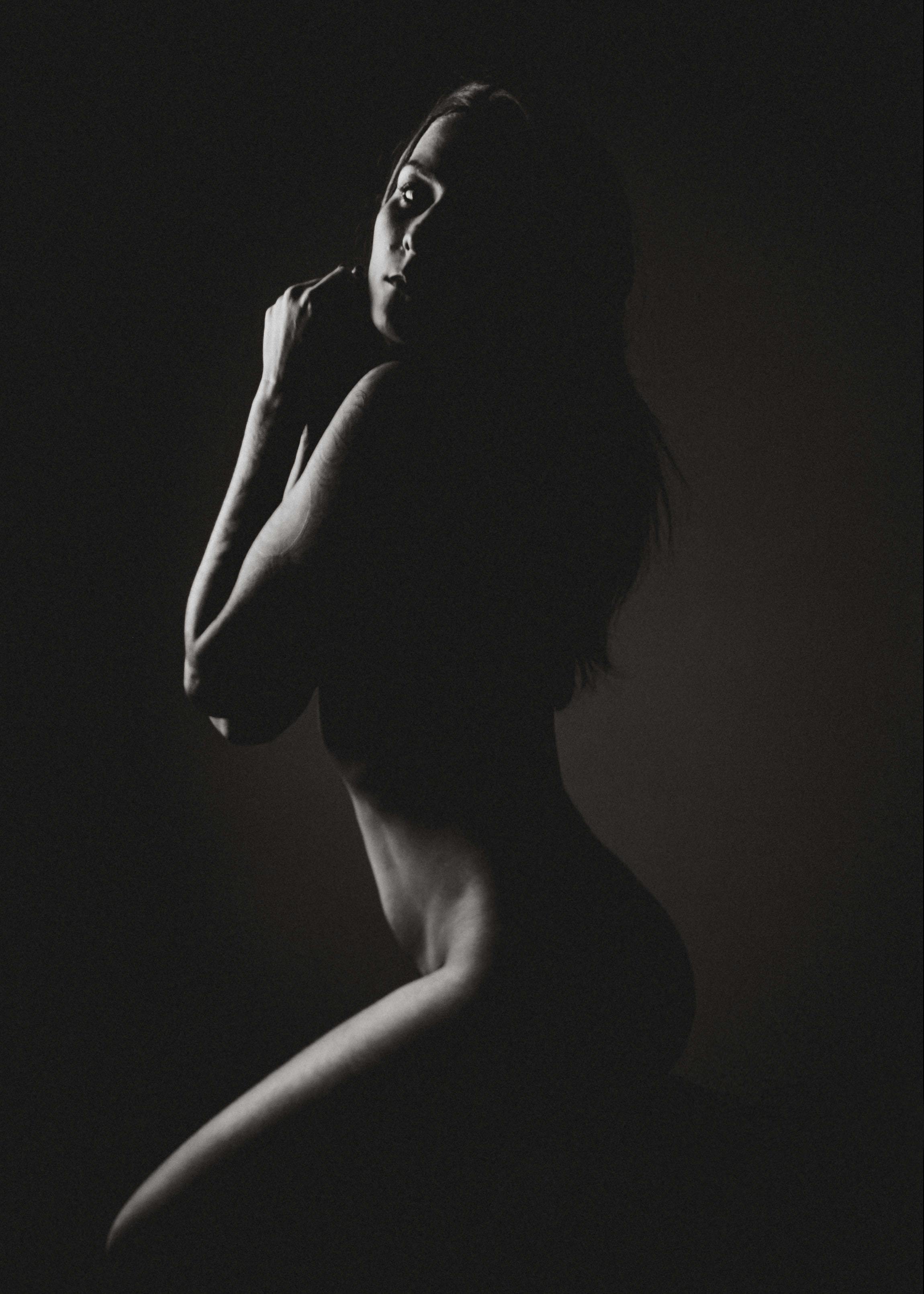 Naked woman in dark studio Free Stock Photo