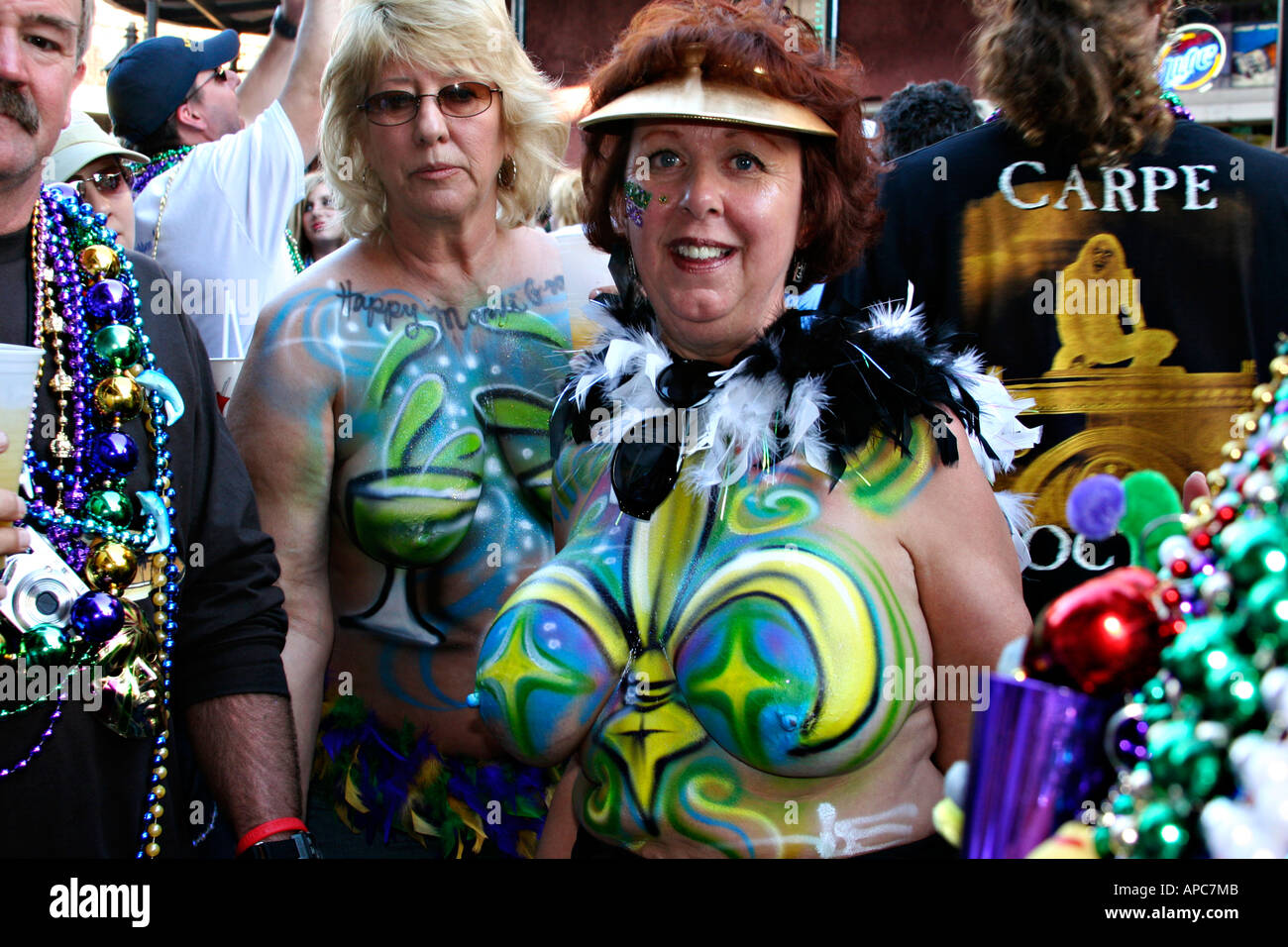 Older women topless and with painted breasts on bourbon street in new orleans Stock Photo