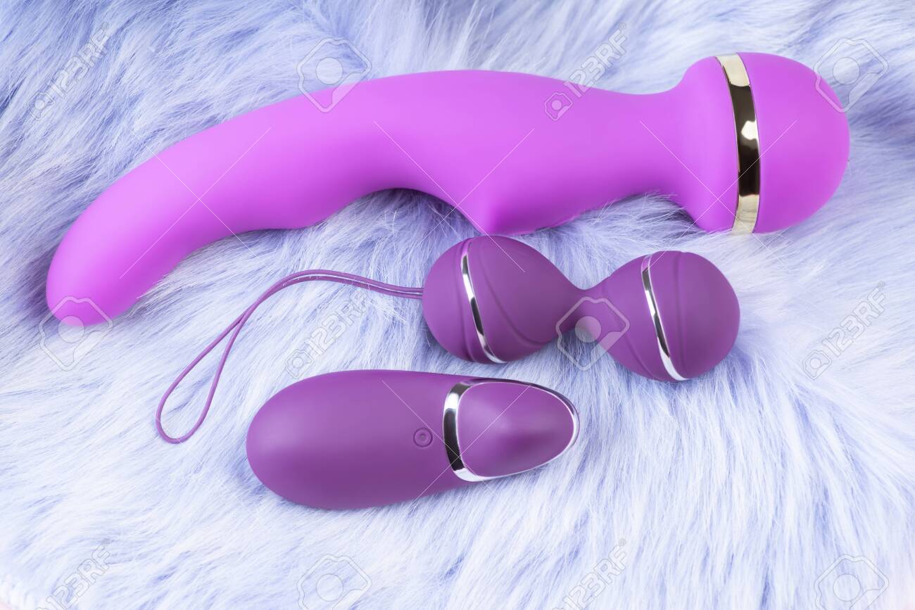 Double Vaginal Balls And Dildo Vibrator.Sex Toy For Adult.Pink Vaginal Balls And Dildo On Aviolet Background With Remote Control. Strengthening The Intimate Muscles Of The Vagina.Womans Health. Stock Photo Picture and