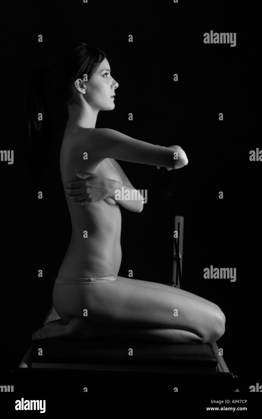 nude woman doing pilates exercise kneeling Stock Photo