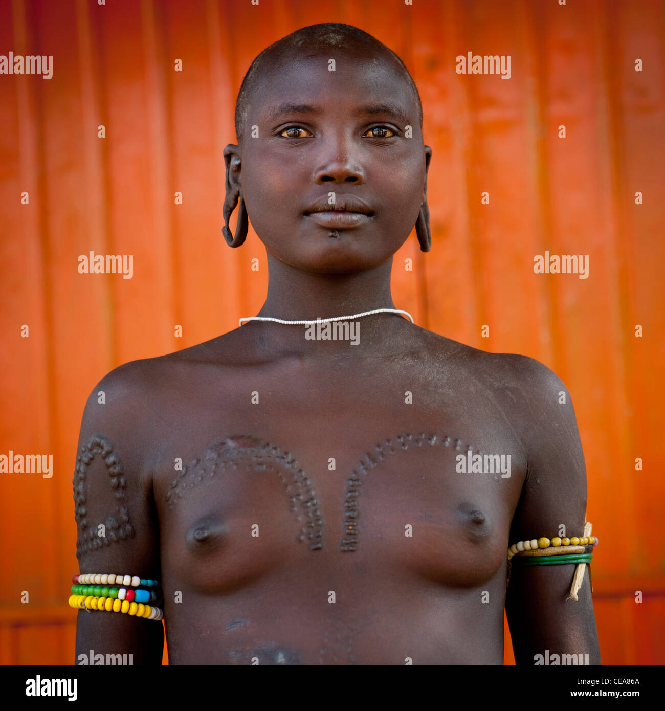 Mursi Topless Shaved Head Extended Earlobes And Scarified Woman Posing Omo Valley Ethiopia Stock Photo