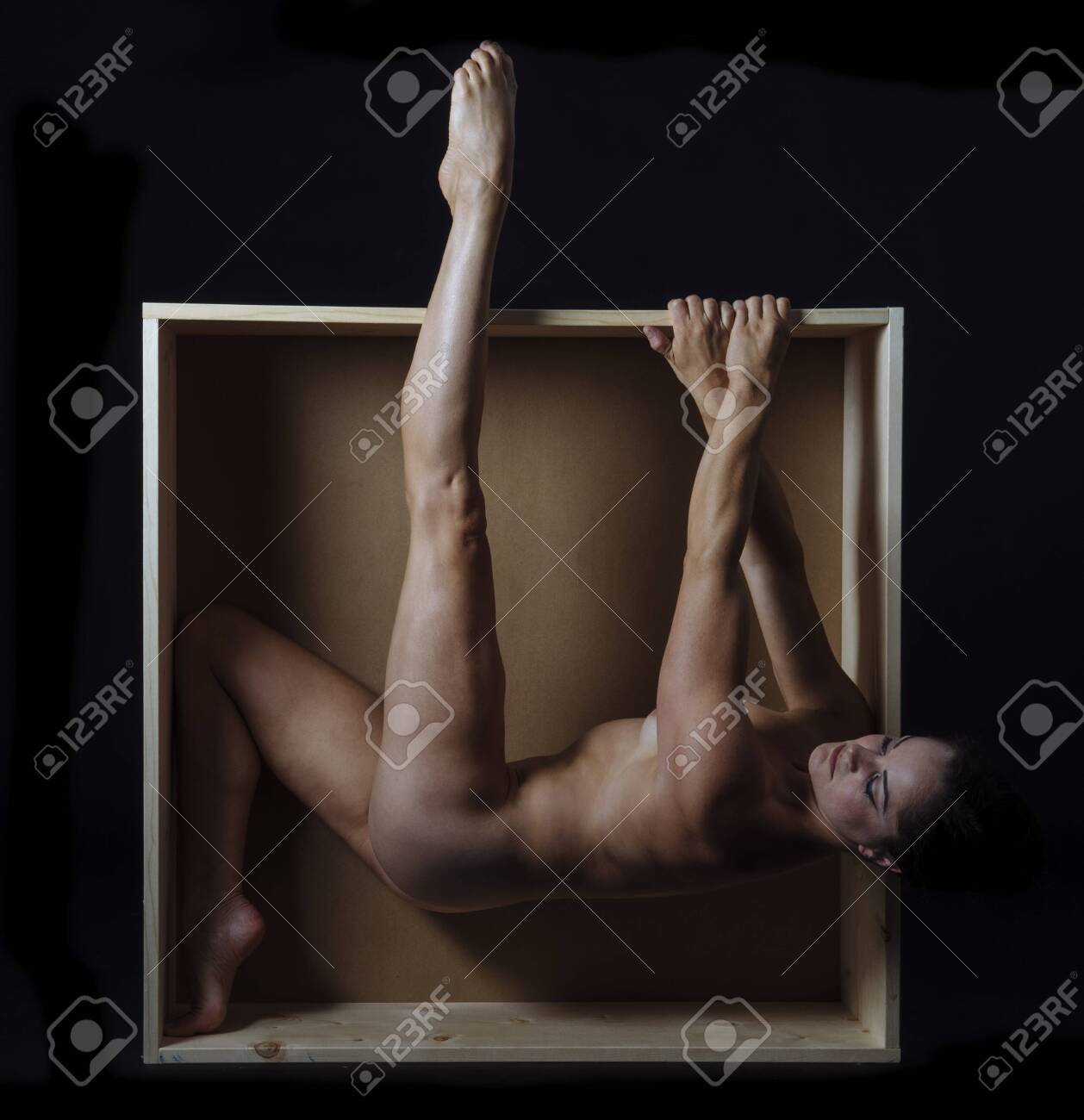 Naked Woman Hanging From Edge Of Box Stock Photo Picture and Royalty Free Image. Image 140607788.