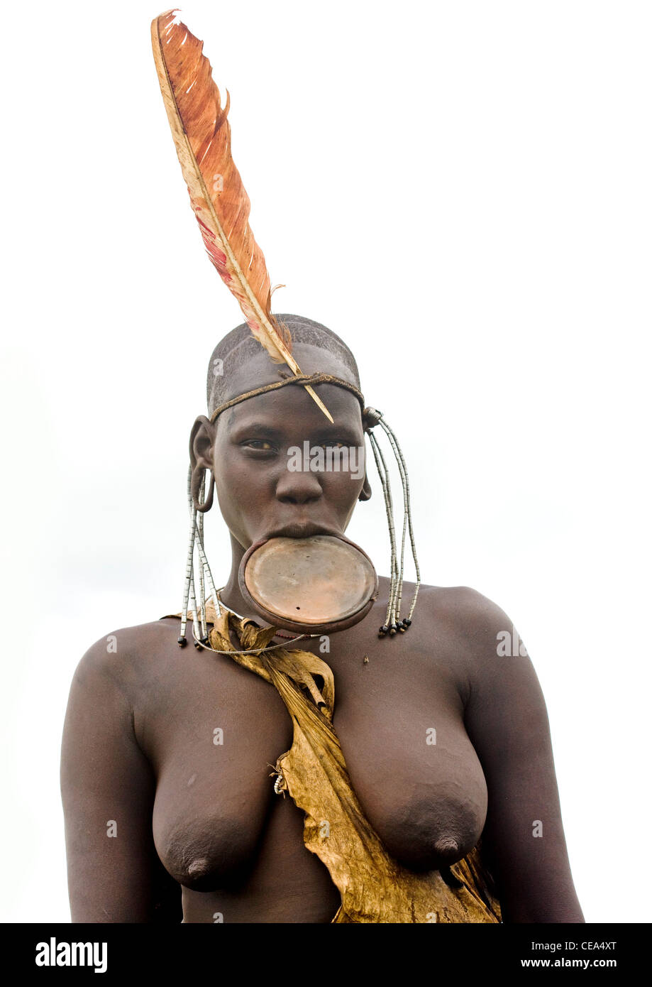 Mursi Woman With Feather On Head And Naked Breasts And Lip Plate On Ethiopia Stock Photo