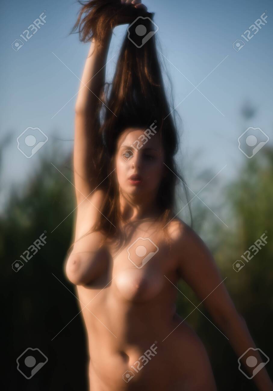 Beautiful Naked Girl Outdoors Enjoying Nature. Soft Focus Blurred Image Of A Nude Woman Posing On The Beach. Image In A Soft Romantic And Vintage Style Stock Photo Picture and Royalty Free