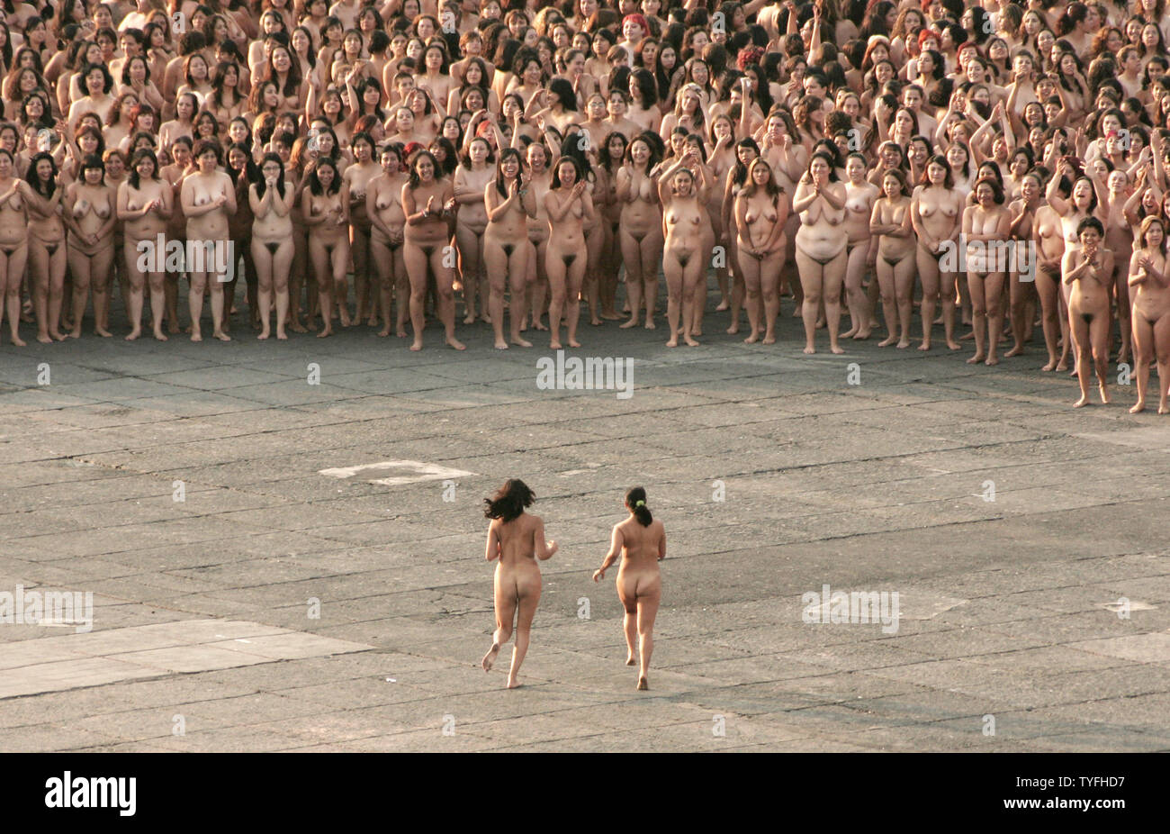 Two women join thousands of other nude volunteers during American photographer Spencer Tunicks installation in Mexico Citys Zocalo on May 6 2007. The controversial artist known for his monumental installations featuring abstract