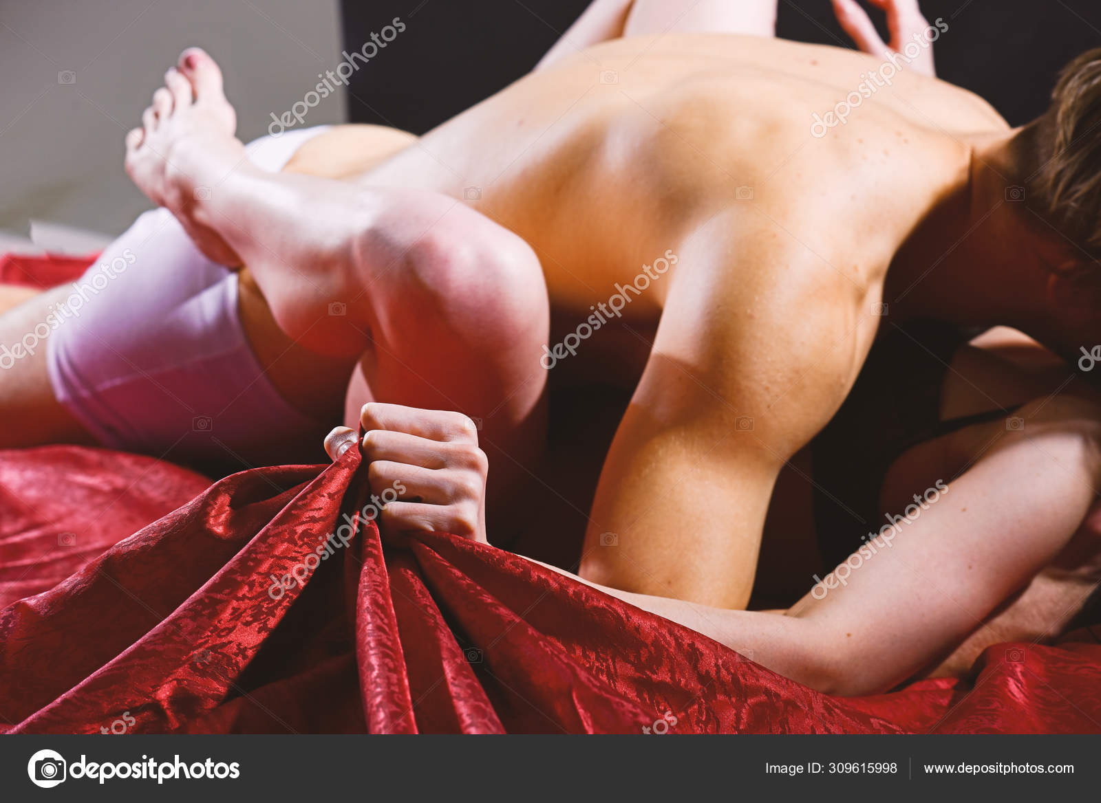 Hand squeeze bedclothes. Naked lovers passionate sex. Woman embrace lover by legs. Passionate couple have sex make love. Female orgasm. Sex and pleasure concept. Feeling of intense sexual pleasure Stock Photo