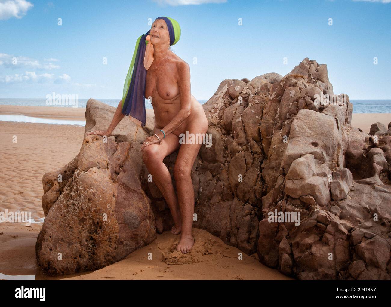 Mature nude woman at the beach Stock Photo