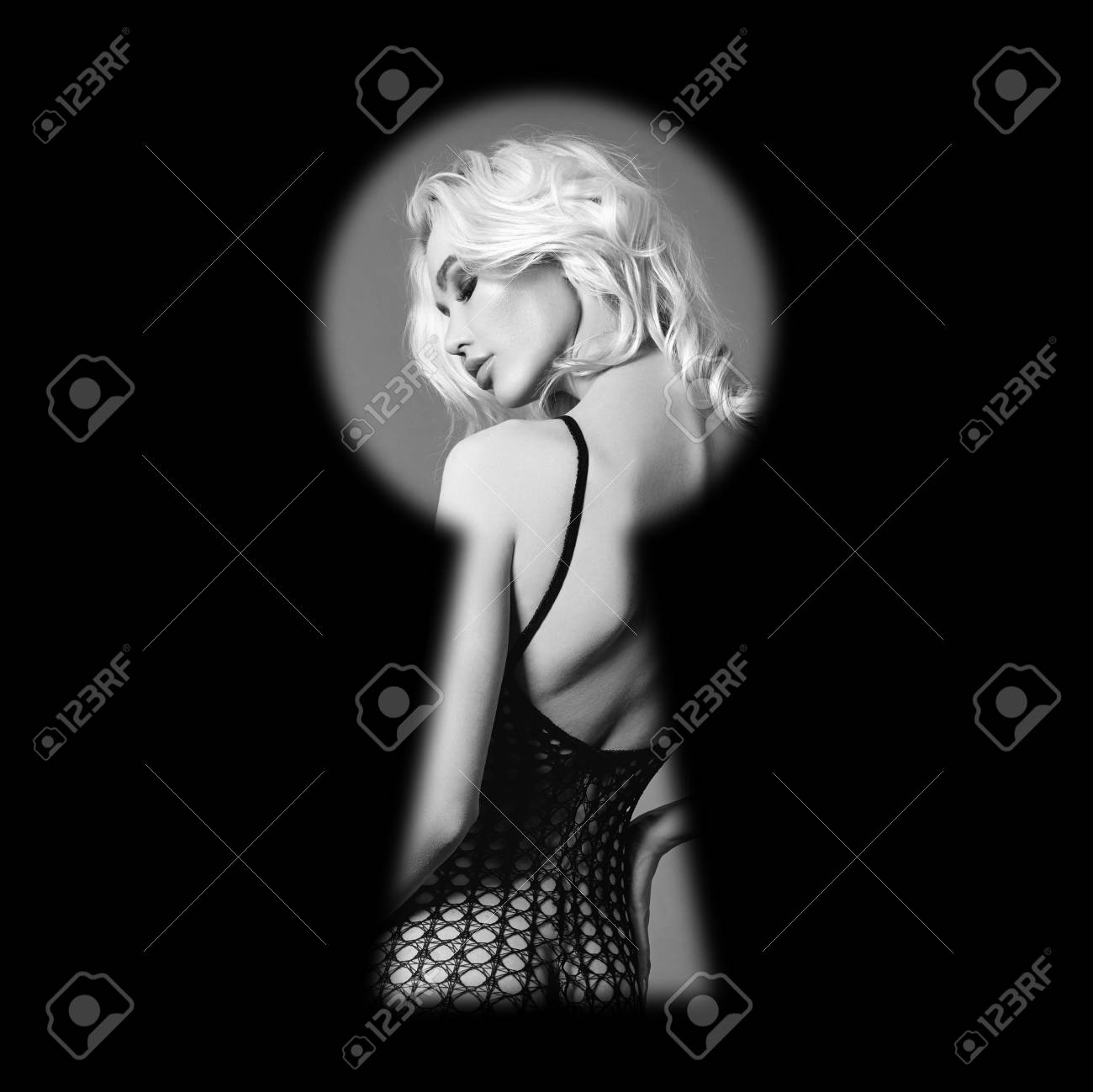 Man spies on naked woman in keyhole of the door an invasion of privacy. Covert surveillance of naked girl. A man secretly looks at woman undressing through keyhole. Sexy beautiful woman outside