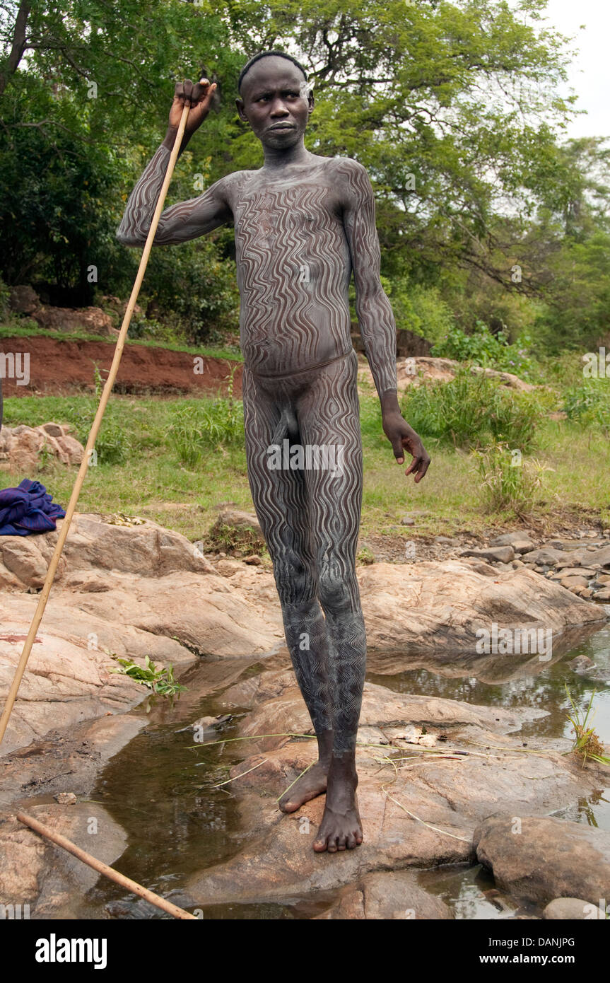 A Suri Surma naked young man body painted with mud Ethiopia Stock Photo