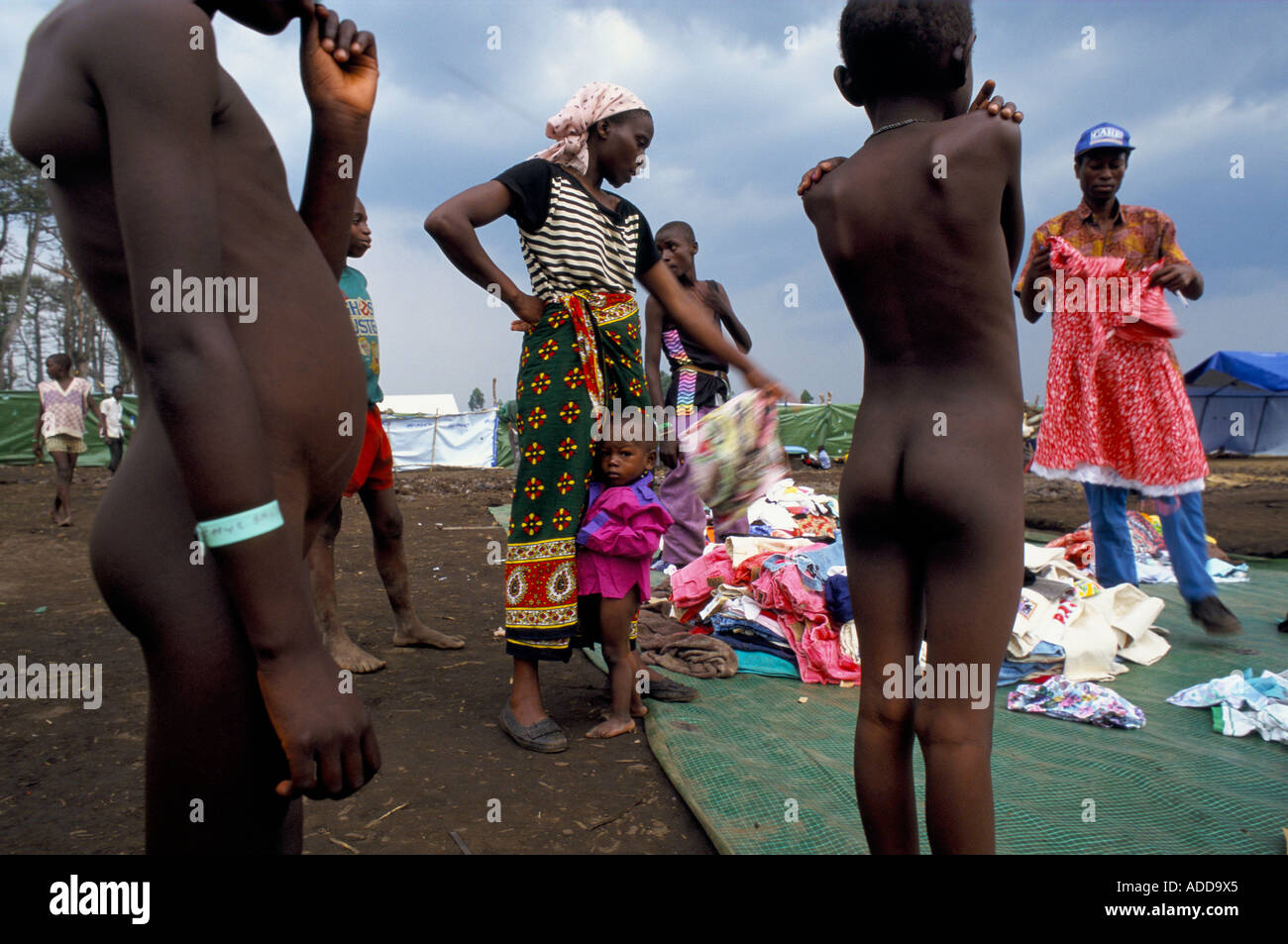 Katale camp Goma: A naked young girl at the Care orphanage at the camp is given a dress from charity donations Stock Photo
