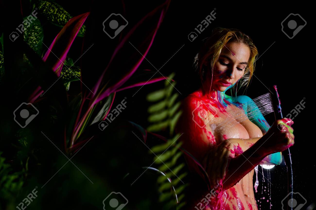 A Woman With Very Large Breasts Washes Body Paint In The Shower. Paint Flows Down The Naked Body Of A Girl In The Bathroom. Stock Photo Picture and Royalty Free Image. Image