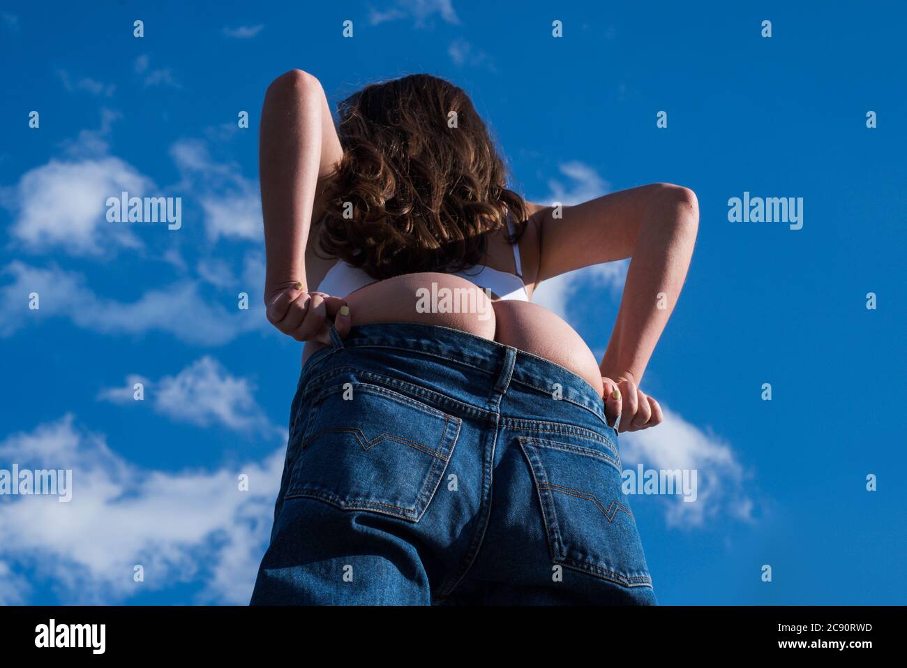 Big buttocks. Sexy girl takes off her pantie and shows a beautiful ass. Girls undressed. Sexy buttocks women in jeans Stock Photo