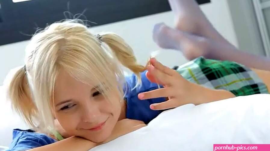 Young blonde lies on the bed and caresses her pussy