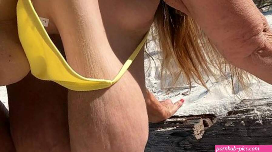 Mature Sarah bouncing on the beach with her massive hanging tits