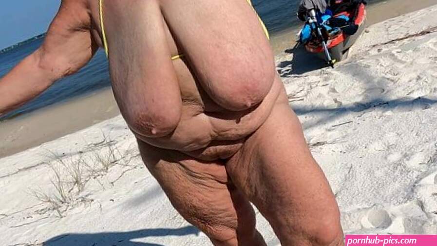 Mature Sarah bouncing on the beach with her massive hanging tits