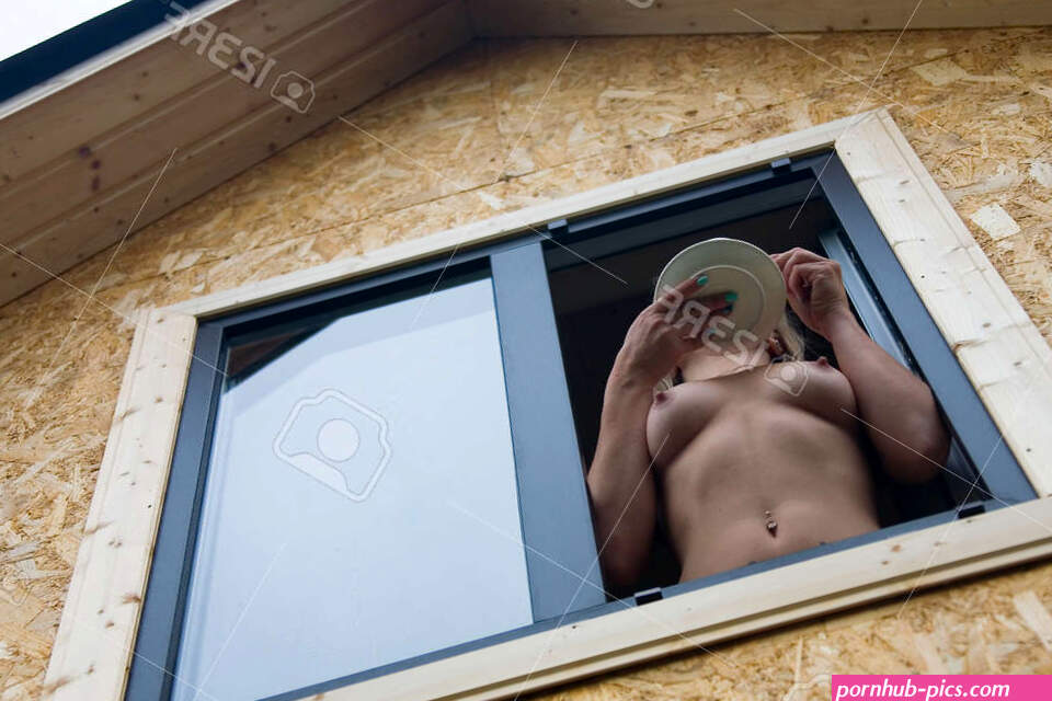 A Naked-chested Girl Holds A Plate In Her Hand And Looks Out Of The Window. View From Below. Stock Photo Picture and Royalty Free Image. Image 136551402.
