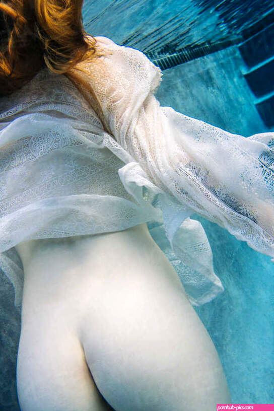 Young woman underwater nude buttocks rear view stock photo