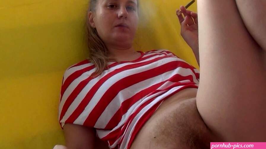 With a naked pussy smoking on the balcony in a T-shirt hairy blonde pussy long hair lazy day