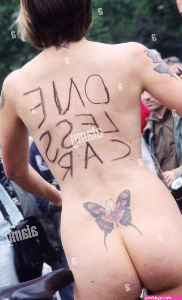 Naked environmentalist: a nude woman with One Less Car written on her bare skin standing tall in the midst of a crowd UK Stock Photo