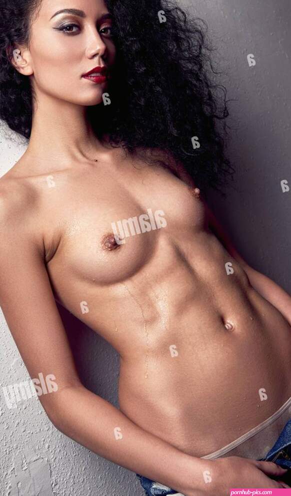 Studio portrait of the sexy nude young girl. Beautiful naked sensual woman dressed in jeans. Seductive sweet lady with curly black hair topless. Er Stock Photo