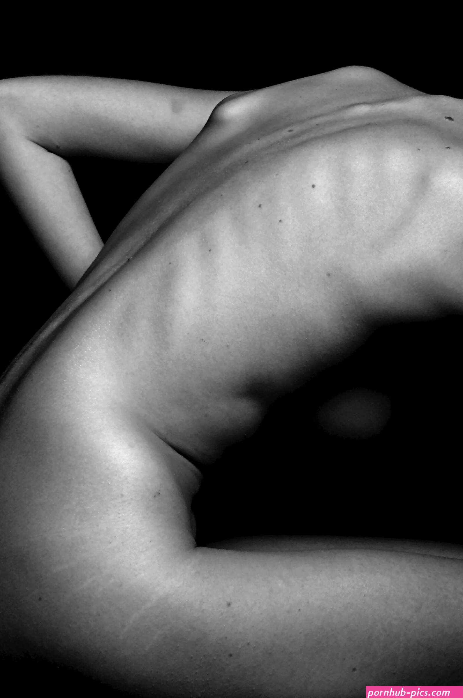 A naked woman sitting on a table with her back to the camera photo