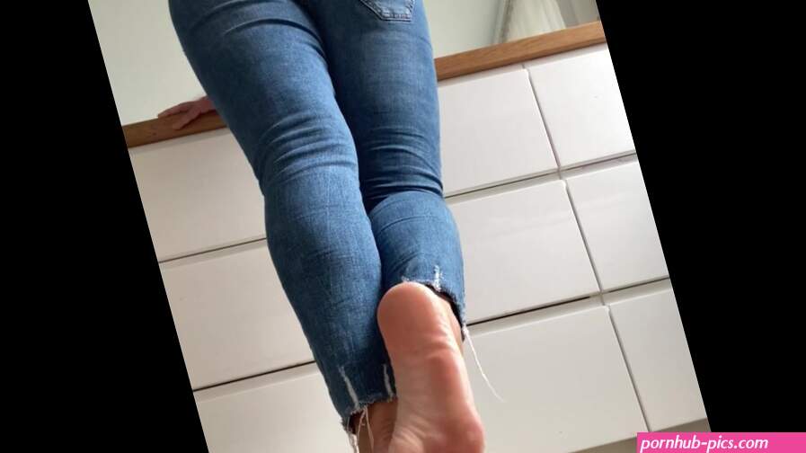 Woman in blue jeans and flip-flops in the kitchen do normal things and showing her feet barefoot