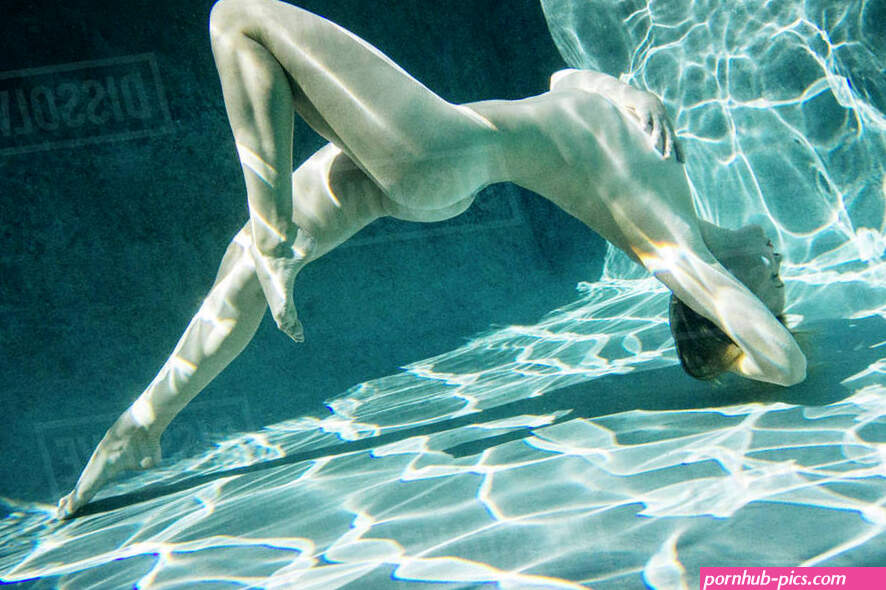 Naked Caucasian woman swimming underwater