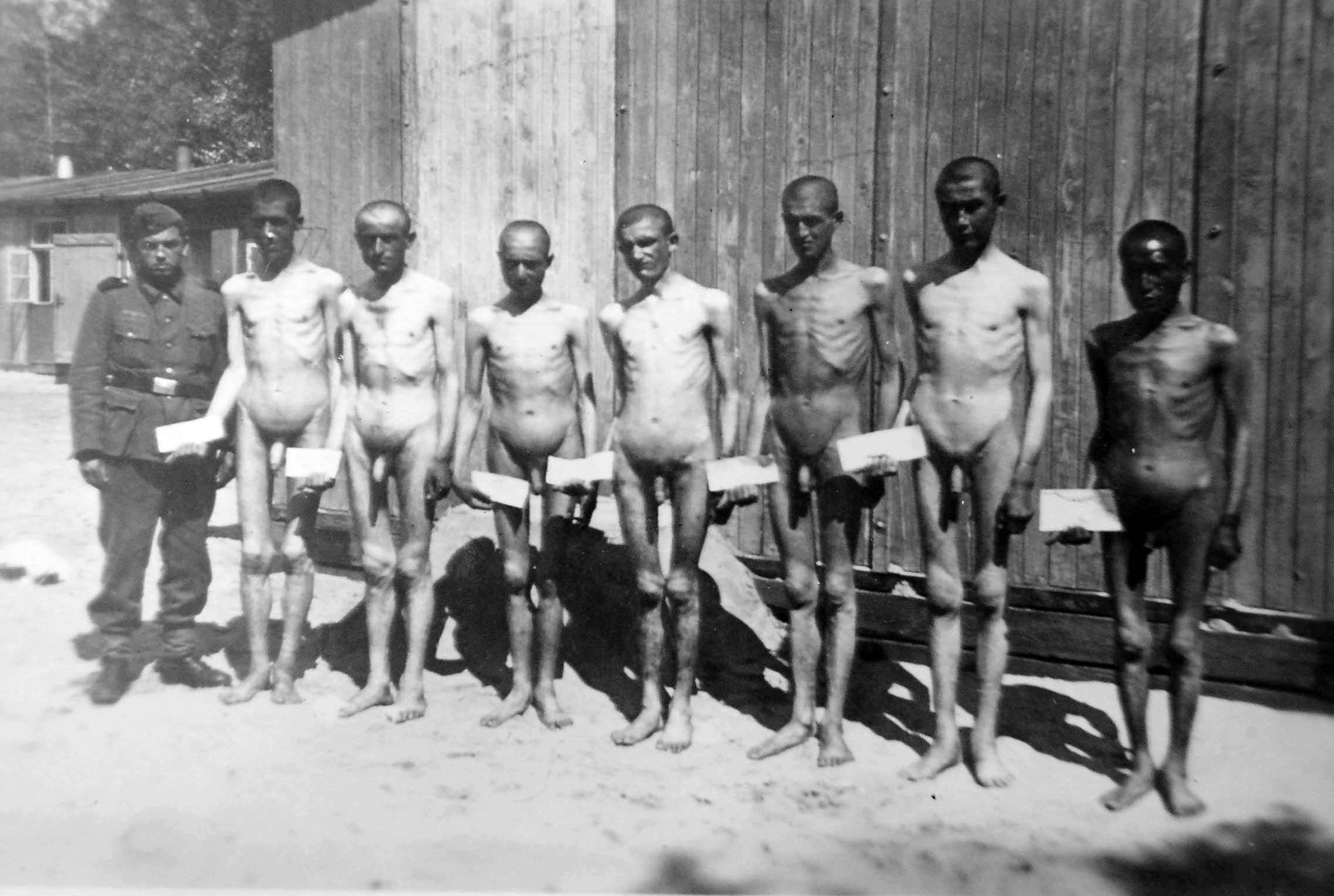 Naked Soviet POWs in a POW camp with a German guard.